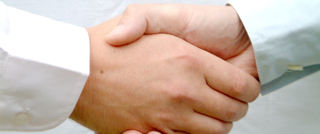 Zwei Menschen schütteln sich die Hände